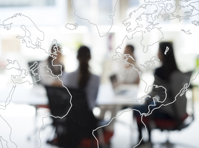 world map overlay team meeting at conference table