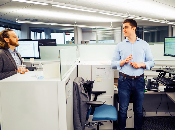 Meaden & Moore team members chatting at their cubicles