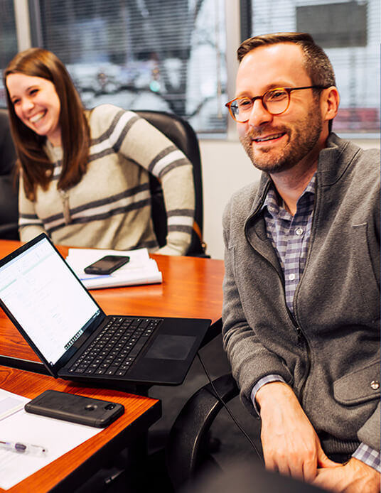 Team members at conference table laughing