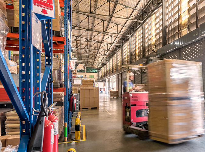 forklift moving large boxes in a warehouse