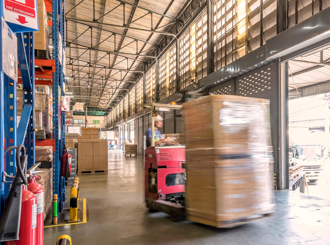 Forklift moving large boxes in warehouse