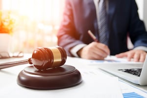 Attorney Working in Courtroom With Wooden Gavel on Table