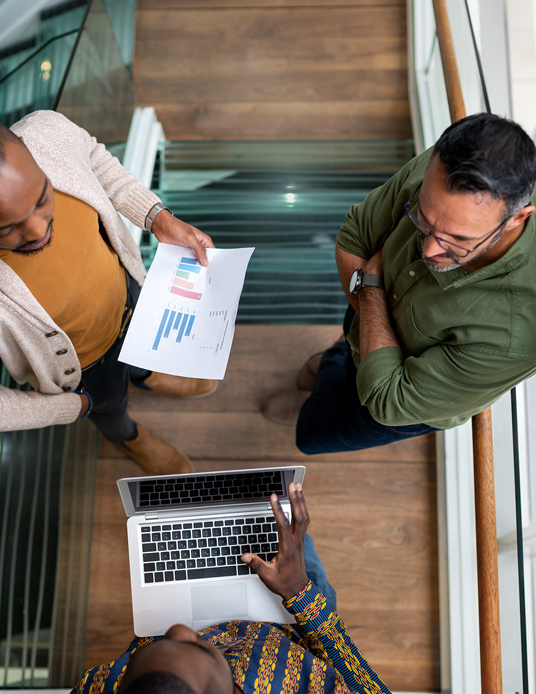 Three men meeting in an office stairway