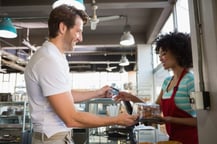 Smiling customer paying by credit card at the bakery-1