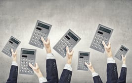 Many hands of business people holding calculators