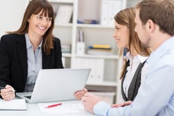 Young couple sitting in an office talking to a woman broker or investment adviser-1