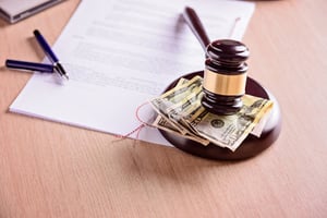 Judge Gavel and Money Next to Judgement on Table