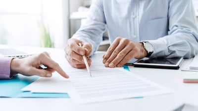 Business People Pointing on a Document and Discussing Together