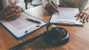 Legal documents and gavel on a wood desk
