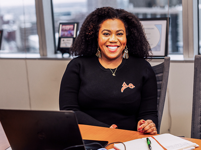 Meaden & Moore team member smiling and sitting at her desk