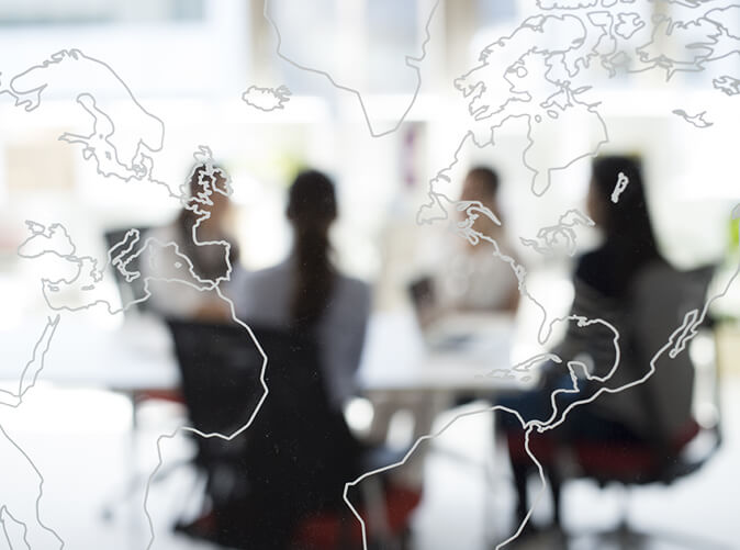 world map overlay team meeting at conference table