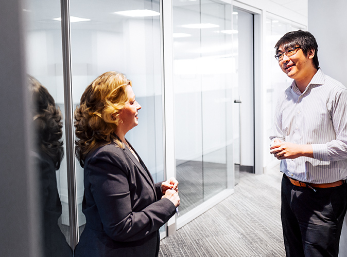 professionals chatting in the office hallway