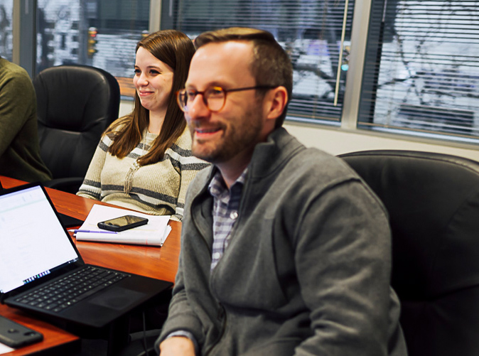 team members meeting at conference room table to discuss consulting & advisory services
