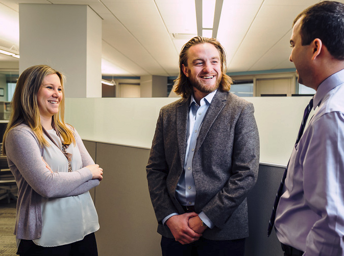 three professionals talking at the office