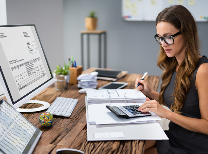 Accounting professional sitting at desk working with calculator