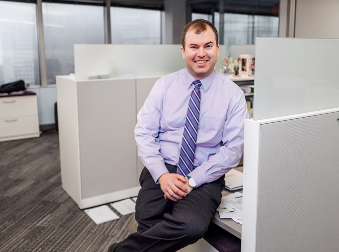 Meaden & Moore professional sitting at cubicle and smiling