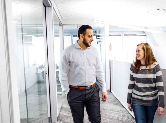 Meaden & Moore team members walking through office and discussing insurance services