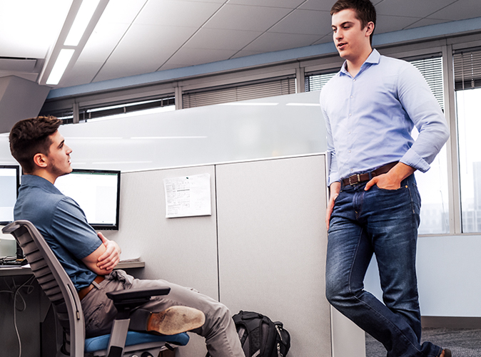 two men talking about tax planning at office cubicle