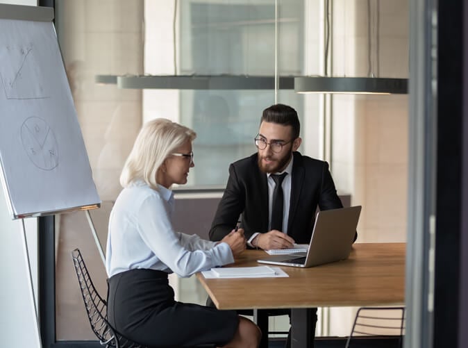 two professionals sitting in conference room discussing international tax issues