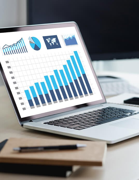 charts displayed on a computer screen notepad and pen