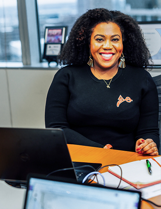 professional woman smiling and sitting at desk