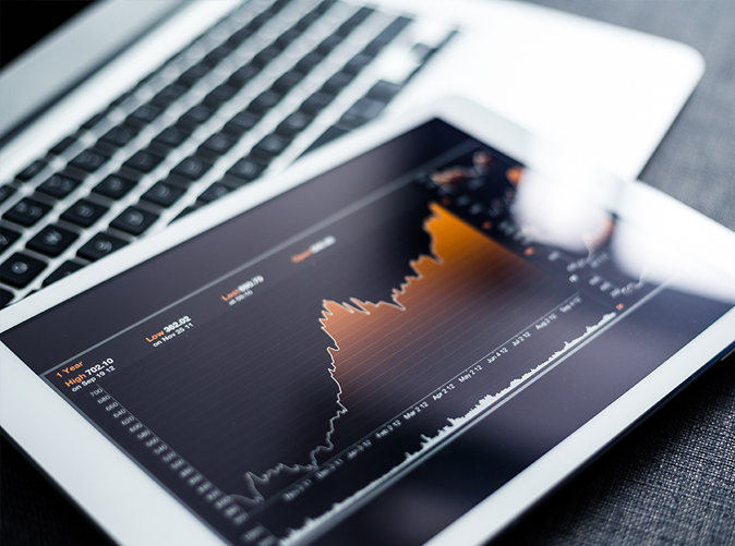 graph on tablet screen and laptop keyboard
