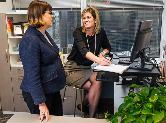 two professional women talking in an office