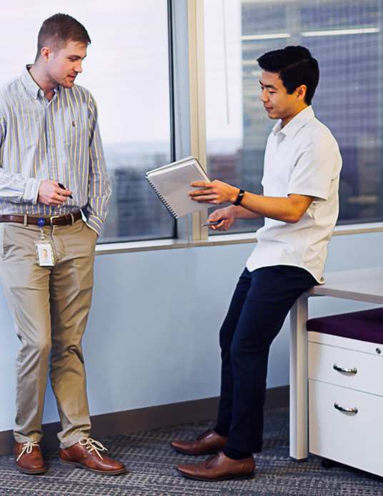 two young professionals talking at the office