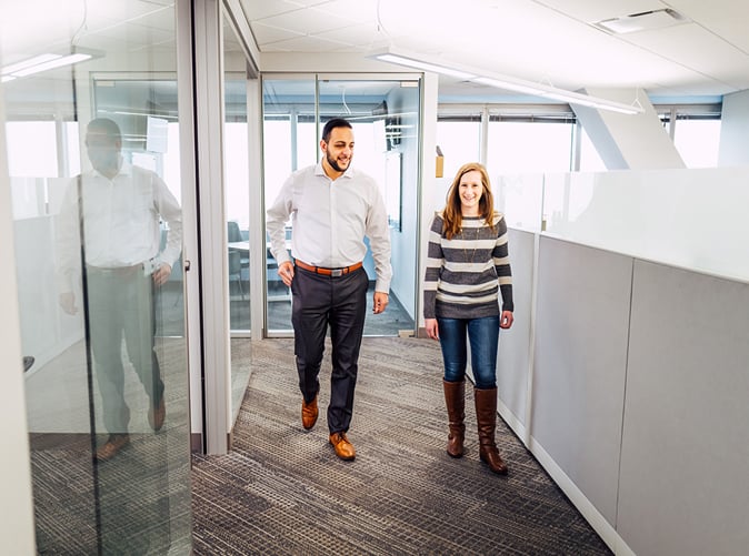 man and woman walking through office