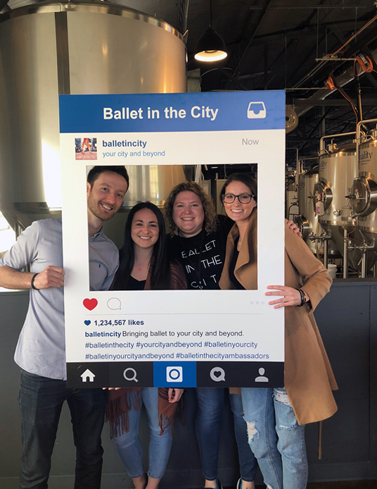 Meaden and Moore team members at culture event with instagram photo cutout prop