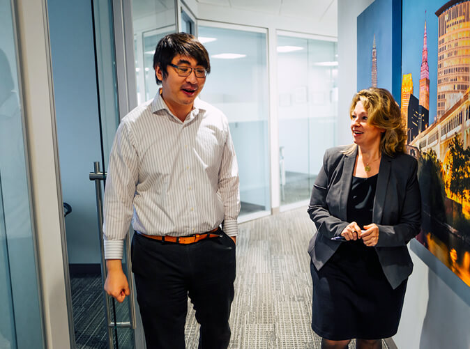 two Meaden and Moore professionals talking in the hallway of an office building